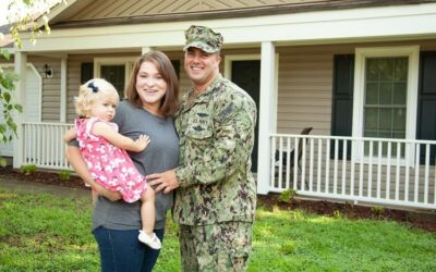 Young military family standing in front of their home