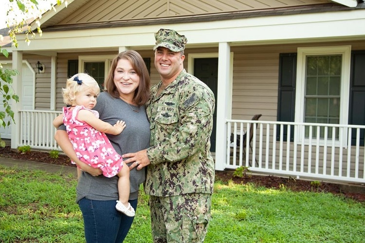 Young military family standing in front of their home