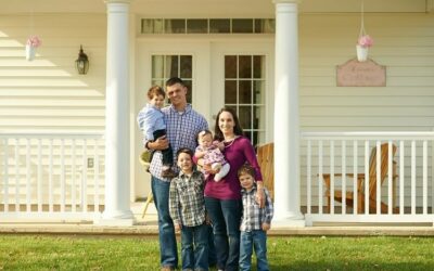 Military family standing in front of their home