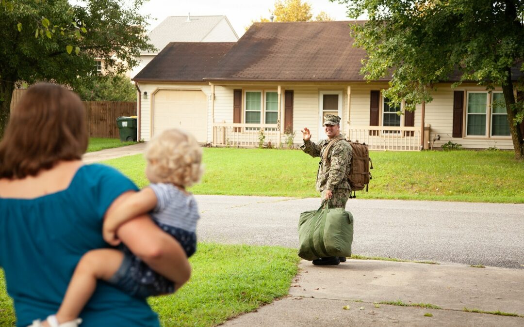 Servicemember waving goodbye to his family as he leaves for deployment