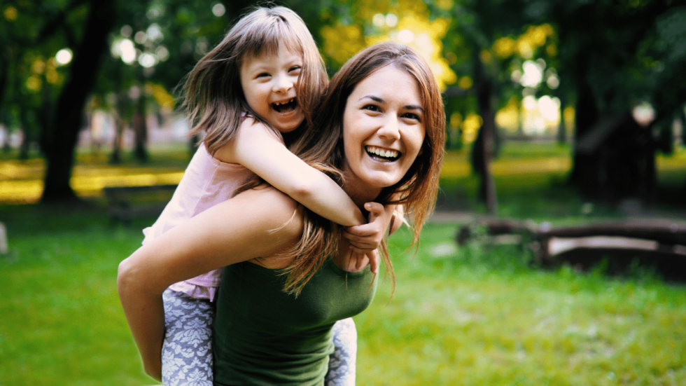 Woman carrying special needs child on her back