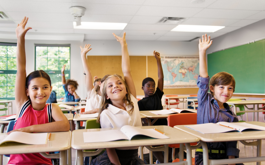 Kids in classroom raising their hands
