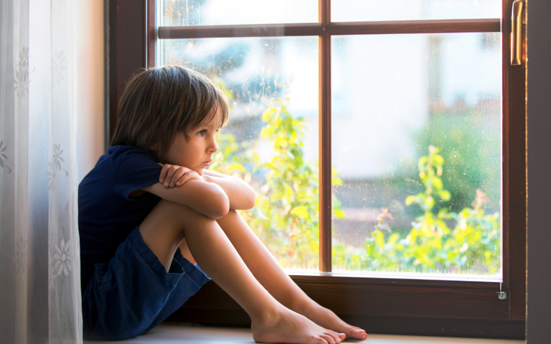 Young boy sitting on a window seat, looking outside