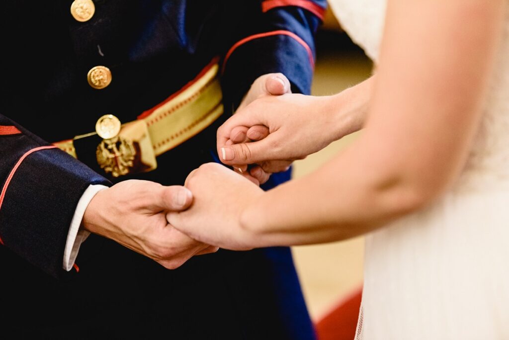 Bride holding hands of her groom in military uniform